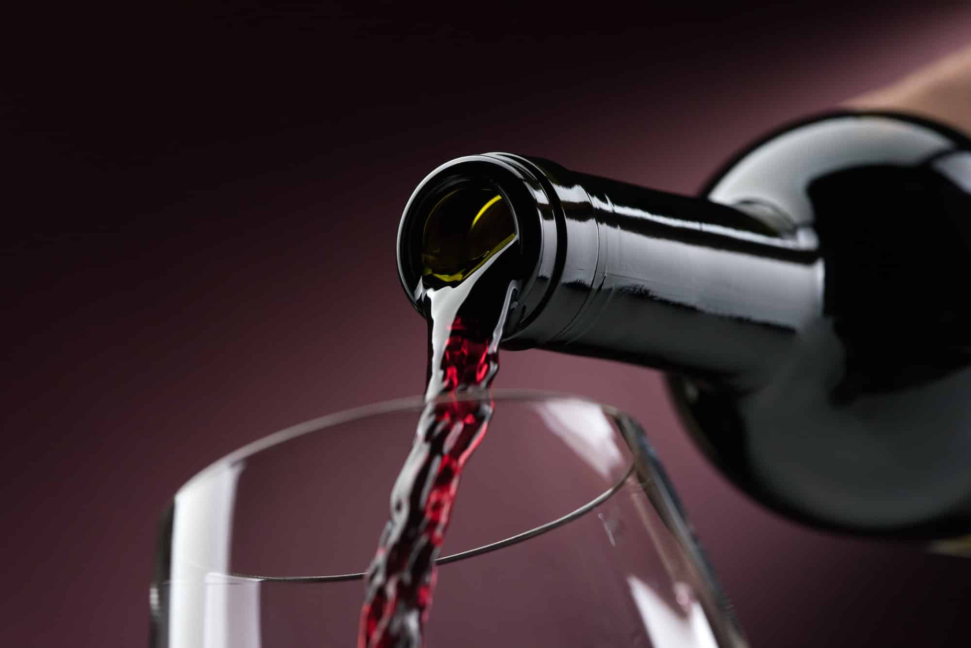 Rotwein in ein Weinglas einschenken